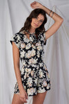 Black Multi Color Floral Print V-Neck Mini Sleeve Tight Fitted Waist Pleated Bottom Romper With Bow Tie Detail - Tasha Apparel Wholesale